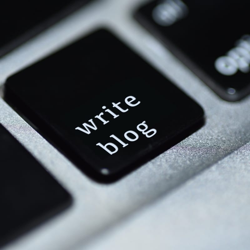 Hands typing a blog post on a laptop